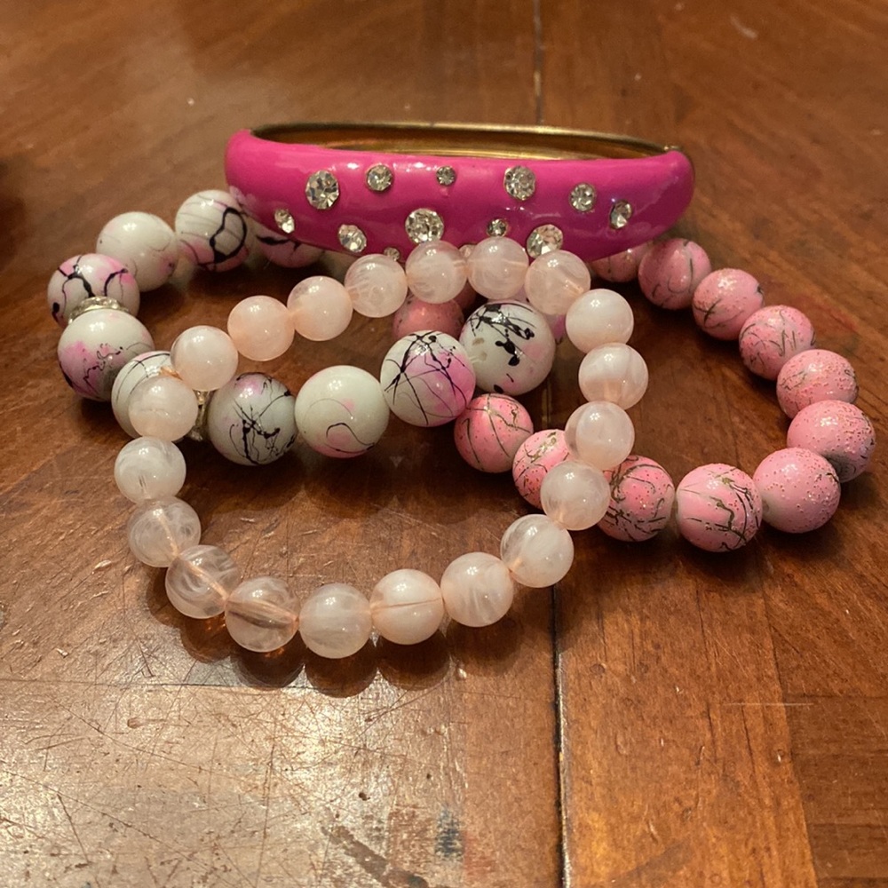 Group of four pink tone bracelets